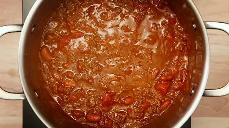 A large pot of chili simmers on a burner