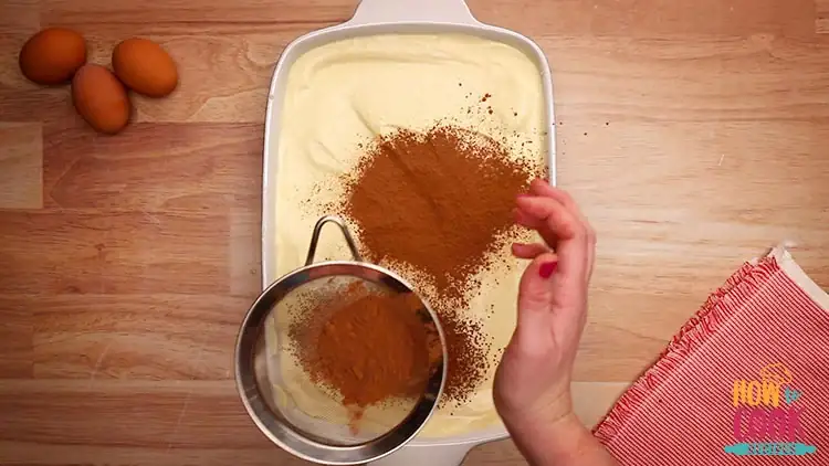 Sifting cocoa over tiramisu