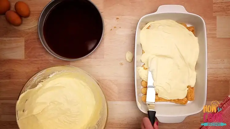 Spreading mascarpone over ladyfingers for tiramisu recipe